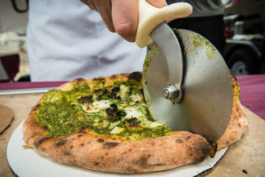 personal pizza being sliced